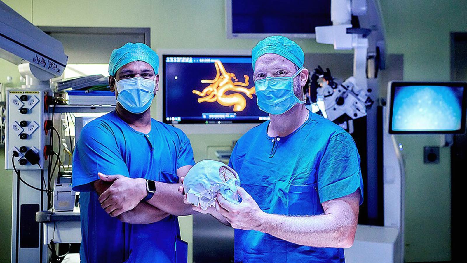 Zwei Neurochirurgen im OP-Saal. Einer der Ärzte hält ein 3D-gedrucktes Schädelmodell, während auf einem Monitor im Hintergrund eine neuronale Bildgebung zu sehen ist.